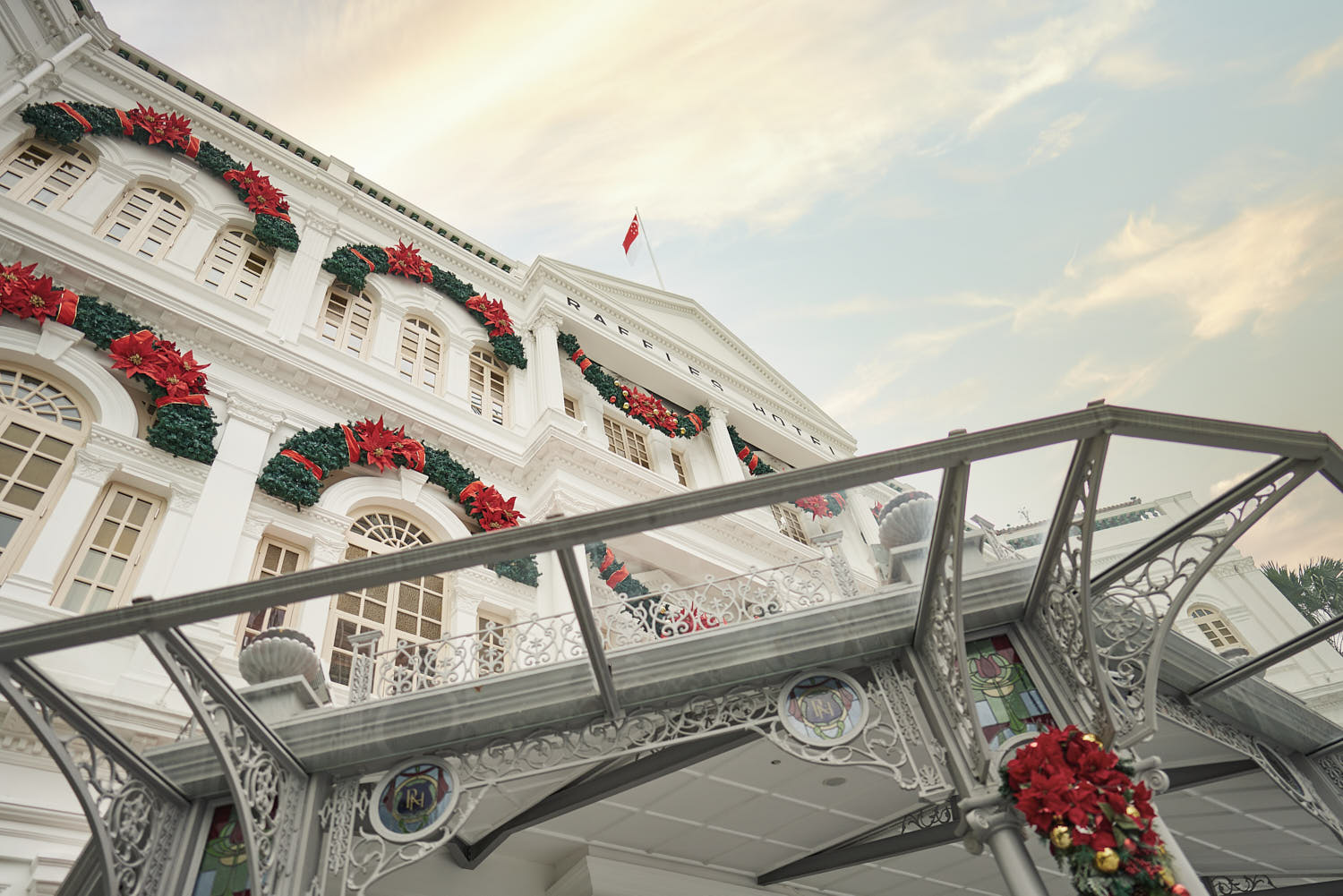 Intricate colonial-era detailing on the white facade of Raffles Hotel Singapore.