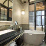 Artyzen Hotel bathroom with a freestanding bathtub, modern vanity, and stylish decor.