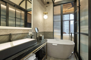 Artyzen Hotel bathroom with a freestanding bathtub, modern vanity, and stylish decor.