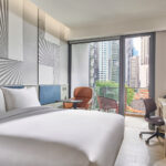 Mercure hotel room with comfortable seating, large windows, and urban views.