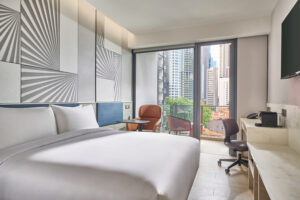 Mercure hotel room with comfortable seating, large windows, and urban views.