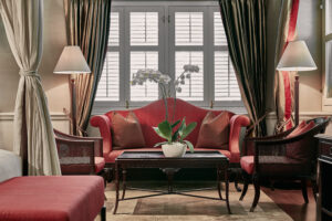 Charming colonial-style room at Capella Hotel Singapore, featuring classic furniture, rich wood accents, and elegant decor.