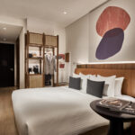 Citadines Connect hotel room with neutral tones, large windows, and stylish decor.