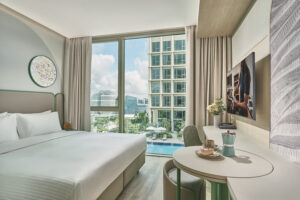 Citadines hotel room with comfortable seating, large windows, and urban views.