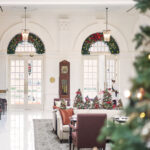 Warm and inviting lobby entrance at Raffles Hotel Singapore, showcasing antique furniture and high ceilings.