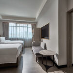 Spacious Novotel Singapore guest room with connecting room and modern minimalist decor.