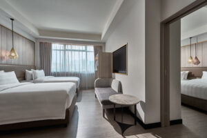 Spacious Novotel Singapore guest room with connecting room and modern minimalist decor.