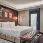 Charming villa-style room with rustic decor, cozy seating, and lush greenery views at The Barracks.