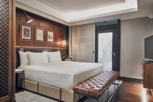 Charming villa-style room with rustic decor, cozy seating, and lush greenery views at The Barracks.
