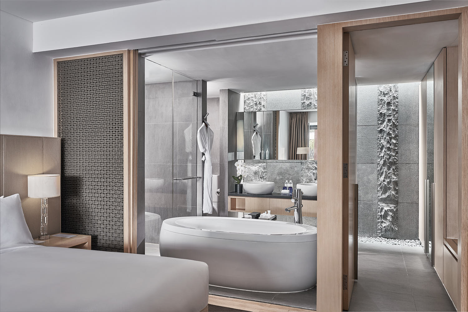 Contemporary hotel bathroom with high-end toiletries, glass shower, and marble countertops at Marriott.