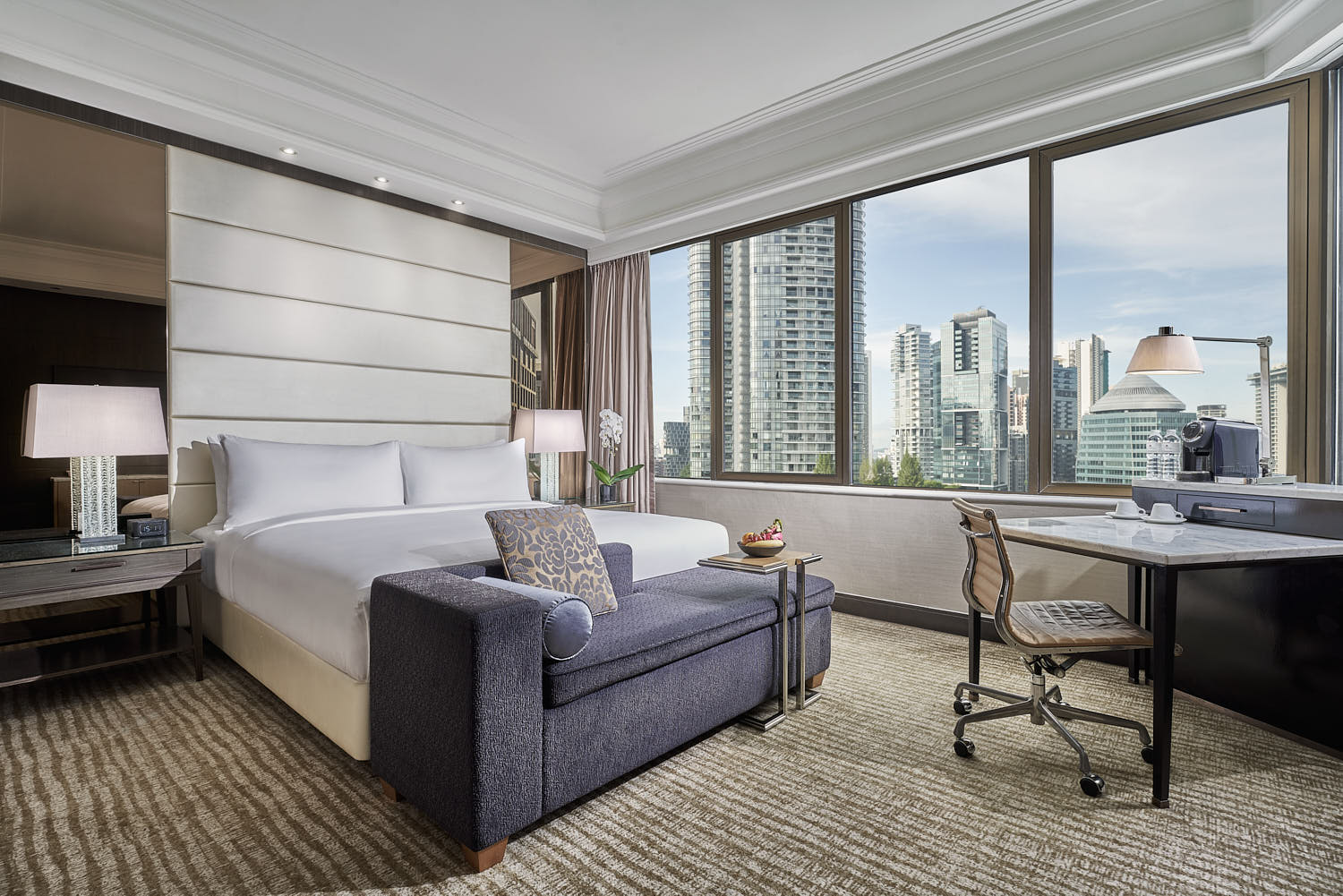 Marriott hotel room with plush bed, elegant decor, and a view of the bustling cityscape.