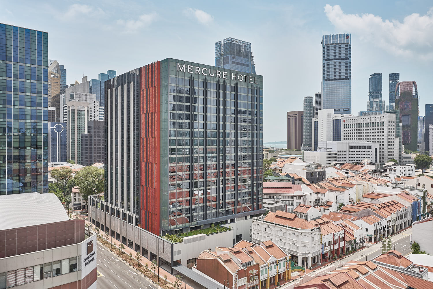 Mercure ICON hotel exterior with glass facade and city skyline views.