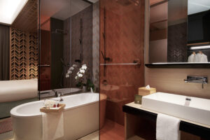 Stylish bathroom with a luxurious bathtub at Oasia Hotel, offering a contemporary, open layout.