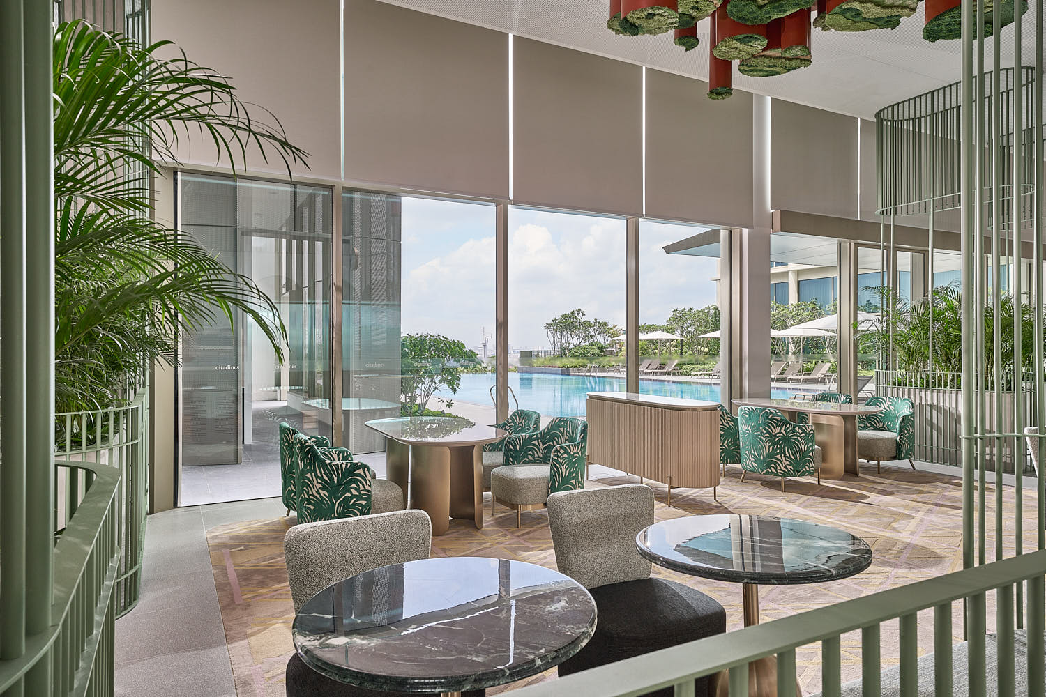 Citadines Science Park lounge with sleek decor and floor-to-ceiling windows overlooking pool.