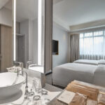 Contemporary bathroom in Novotel Singapore room with a glass-enclosed shower and modern fixtures.