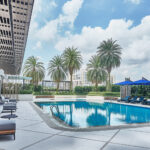 Novotel hotel's elevated swimming pool with lush greenery and contemporary design elements.