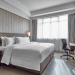 Comfortable and well-appointed Novotel Singapore room with a flat-screen TV and functional workspace.