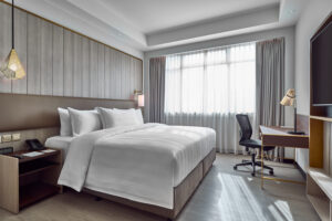 Comfortable and well-appointed Novotel Singapore room with a flat-screen TV and functional workspace.