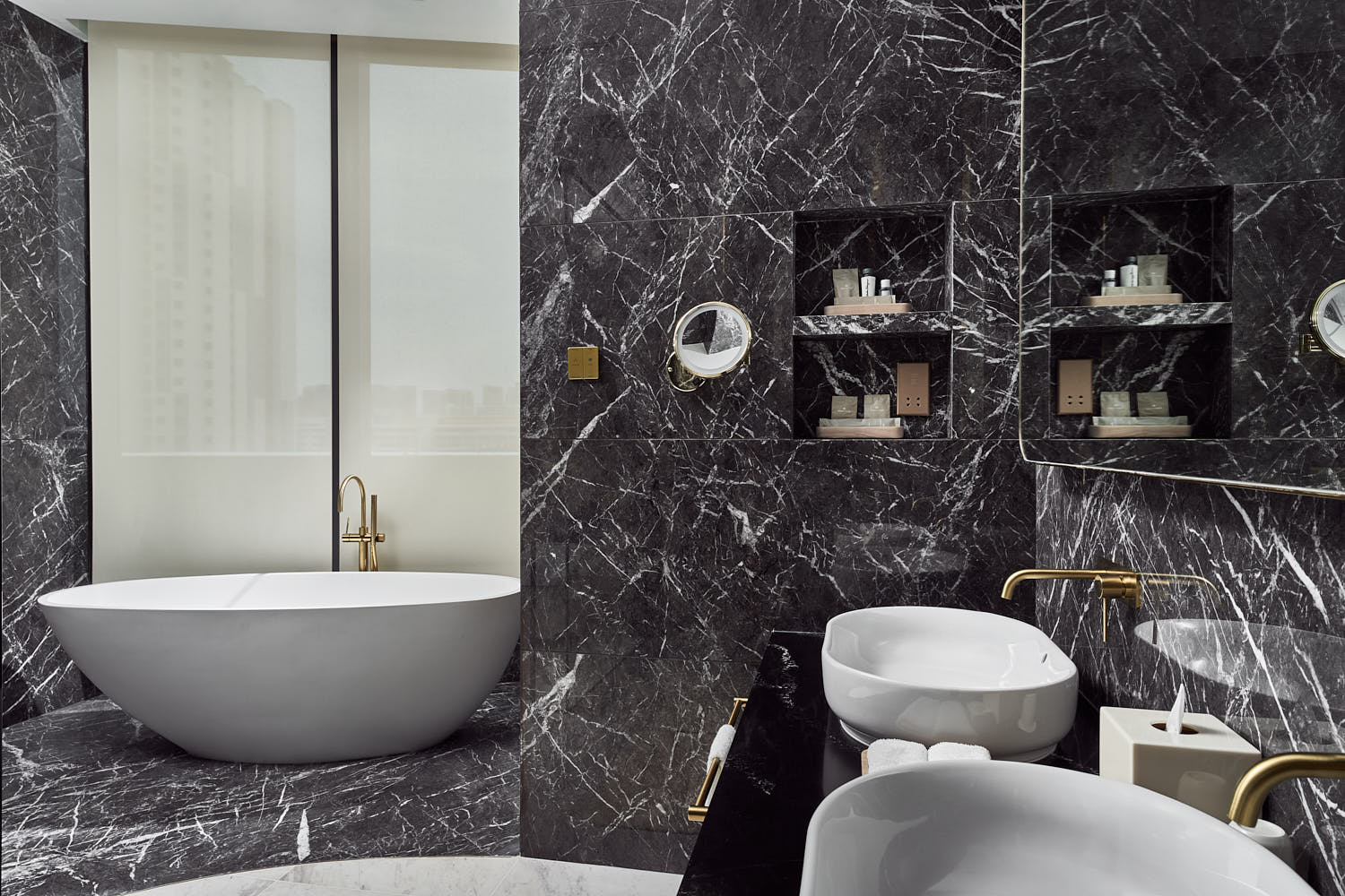 Lavish bathroom with polished marble floors, an elegant soaking tub, and ambient lighting at One Farrer Hotel.