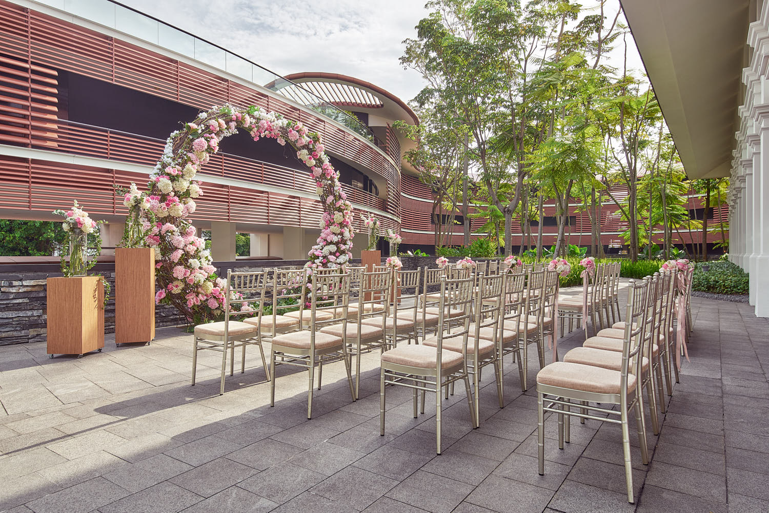 Beautiful open-air wedding venue with stylish seating, flower arch, and nature-filled surroundings at Capella.