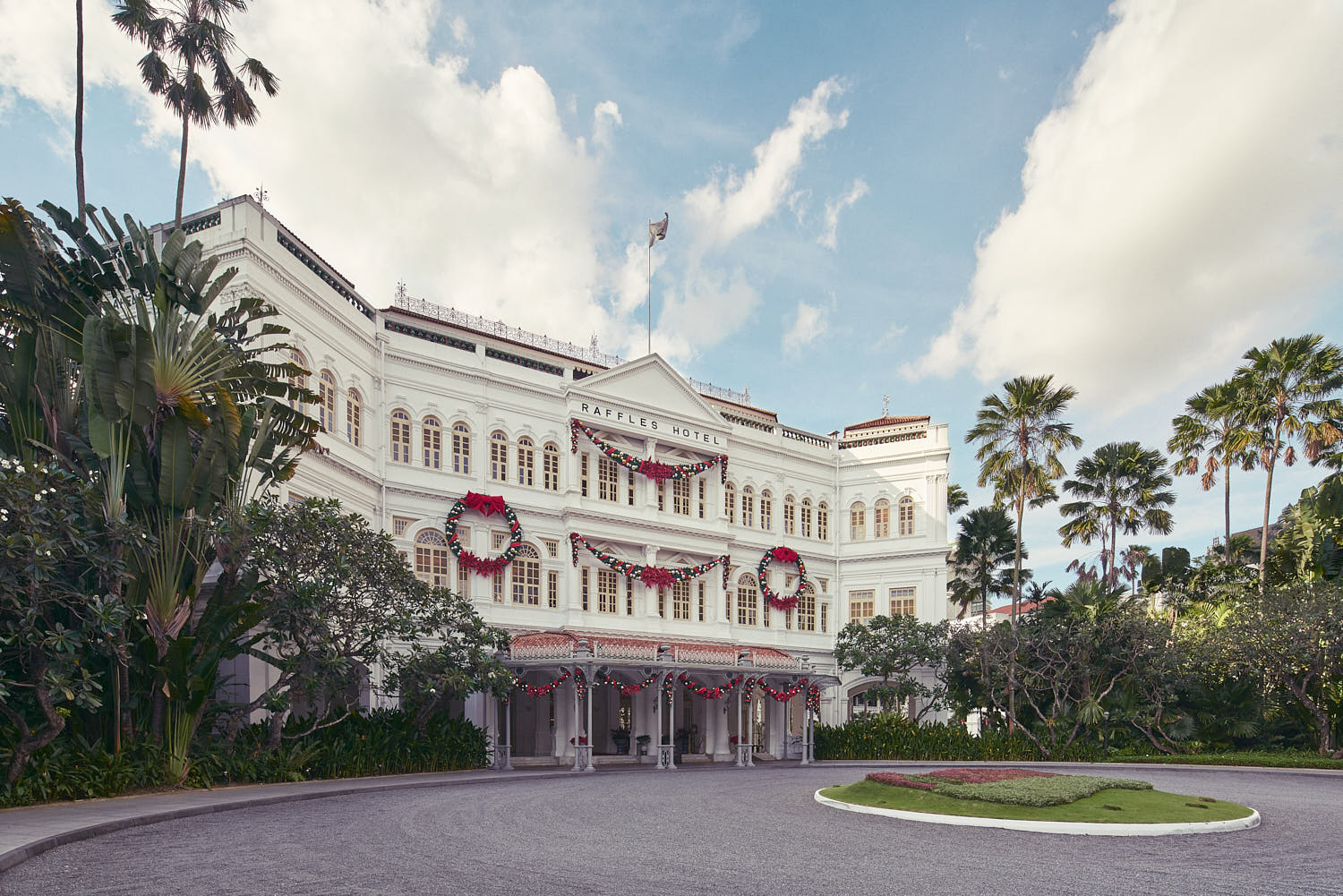 Historic luxury Raffles Hotel with colonial architecture and elegant arches.