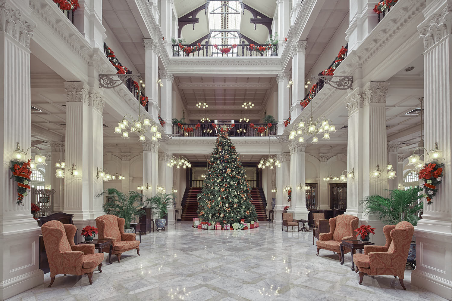 Raffles Hotel Singapore’s grand lobby featuring a festive Christmas tree and seasonal decorations.