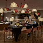 Luxurious lounge space at Sofitel Hotel Singapore with a beautifully set table, showcasing a selection of delicacies and drinks.