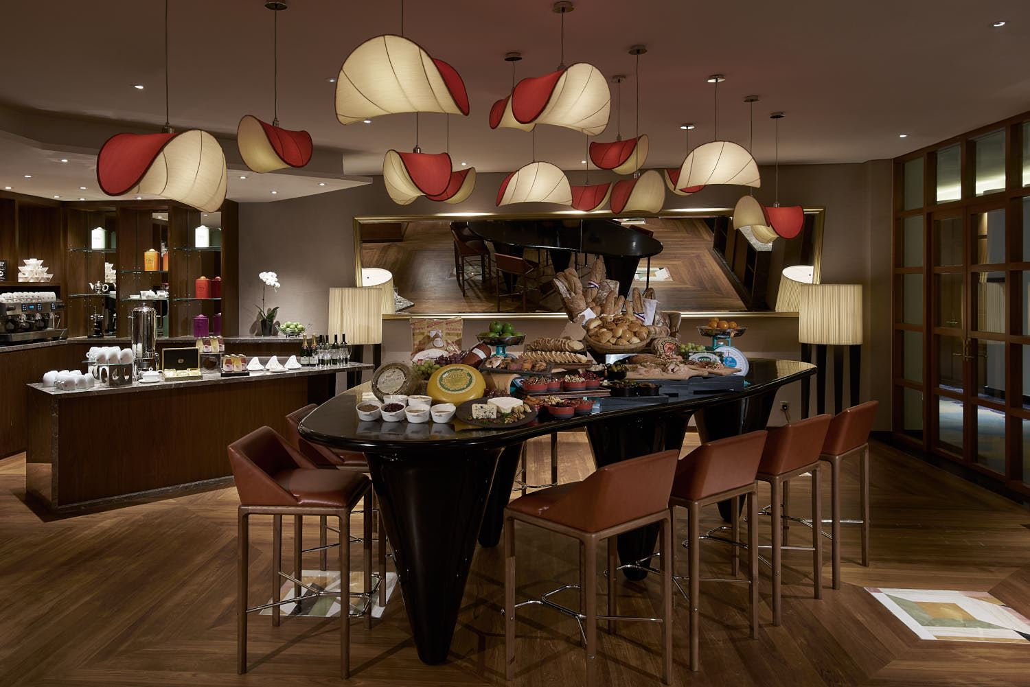 Luxurious lounge space at Sofitel Hotel Singapore with a beautifully set table, showcasing a selection of delicacies and drinks.