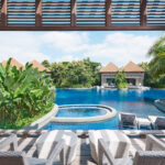 Tropical resort pool at Equarius Villas at RWS, featuring a spacious deck, lush greenery, and tranquil surroundings.
