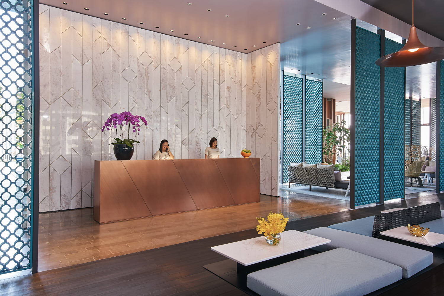 Oasia Downtown lobby with modern furnishings, high ceilings, and artful design.