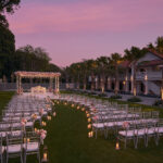 Grand outdoor sunset wedding setup at The Barracks Hotel Singapore, featuring a lavish floral arch and spacious garden.