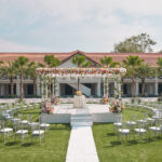 Romantic grand wedding setup at The Barracks Hotel, complete with a flower-lined aisle and vibrant colors.