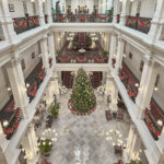 Grand overview of the lobby at Raffles Hotel Singapore, showcasing elegant chandeliers, luxurious seating, and classic design.
