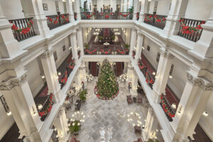 Grand overview of the lobby at Raffles Hotel Singapore, showcasing elegant chandeliers, luxurious seating, and classic design.