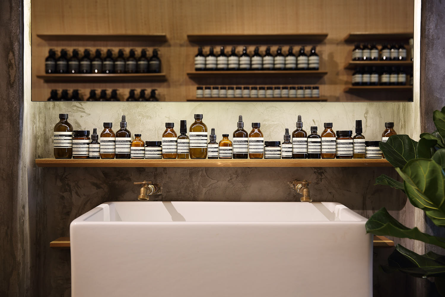 Sleek wooden counter in a warm, spacious Aesop interior.