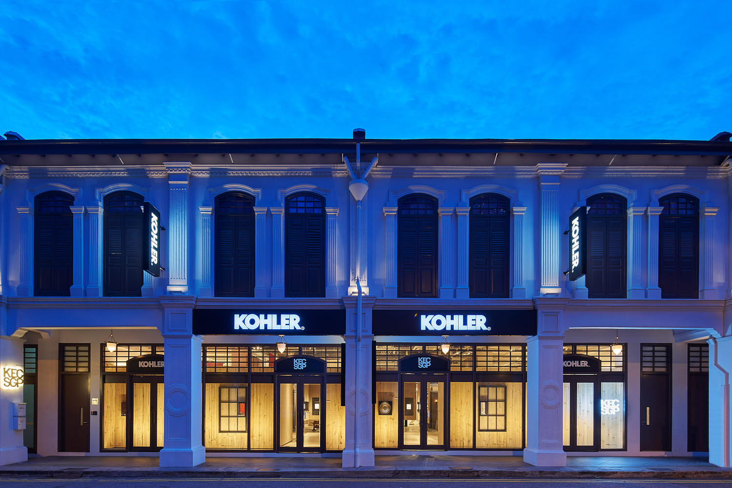 Kohler Experience Center façade at dusk with glowing interior lights.