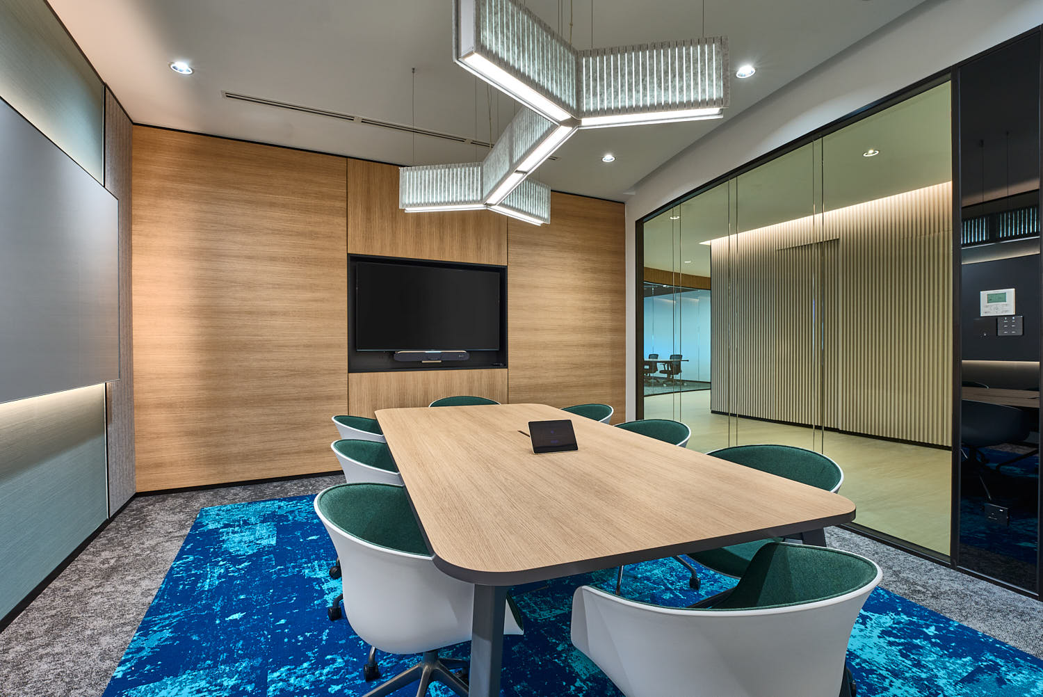 Contemporary meeting room with clean lines, glass walls, and a central conference table.