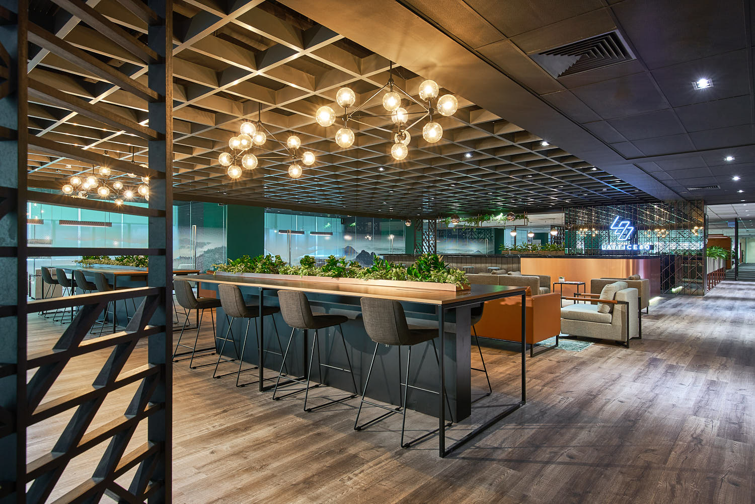 Spacious open-plan office with warm lighting and soft furnishings.