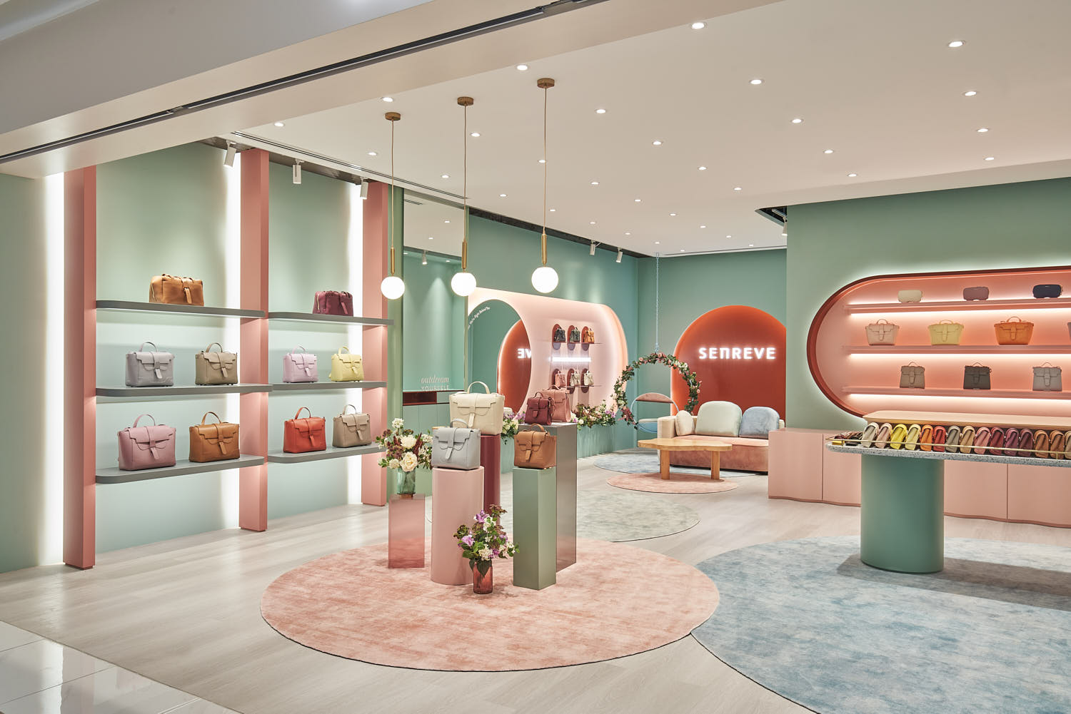 Senreve handbags elegantly arranged on pastel-colored shelves and minimalist tables.