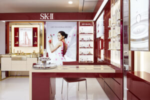 Glossy red and white interior of SK-II store with premium countertop displays.